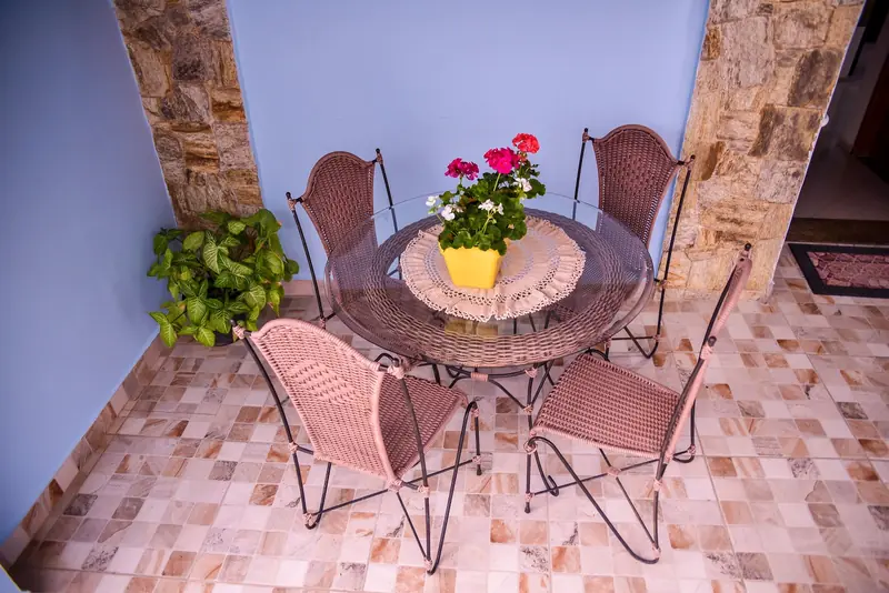 Mesa com flores na varanda de pedra da Vó Dora